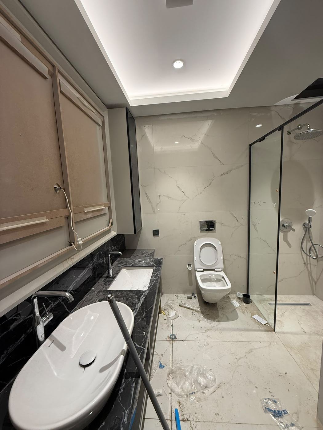Konya banyo temizligi oncesi: mermer duvarlar, lavabo ve zeminde insaat atigi